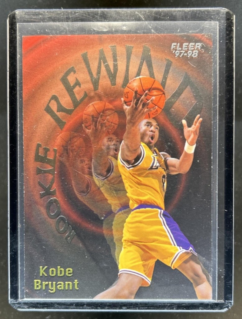 dcsports87 eBay listing photo of the same Kobe Bryant Rookie Rewind card with glare on the toploader